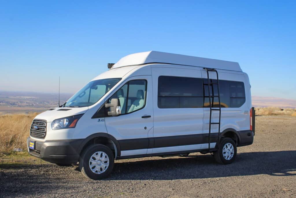 A side view of a white colorado camper van on road