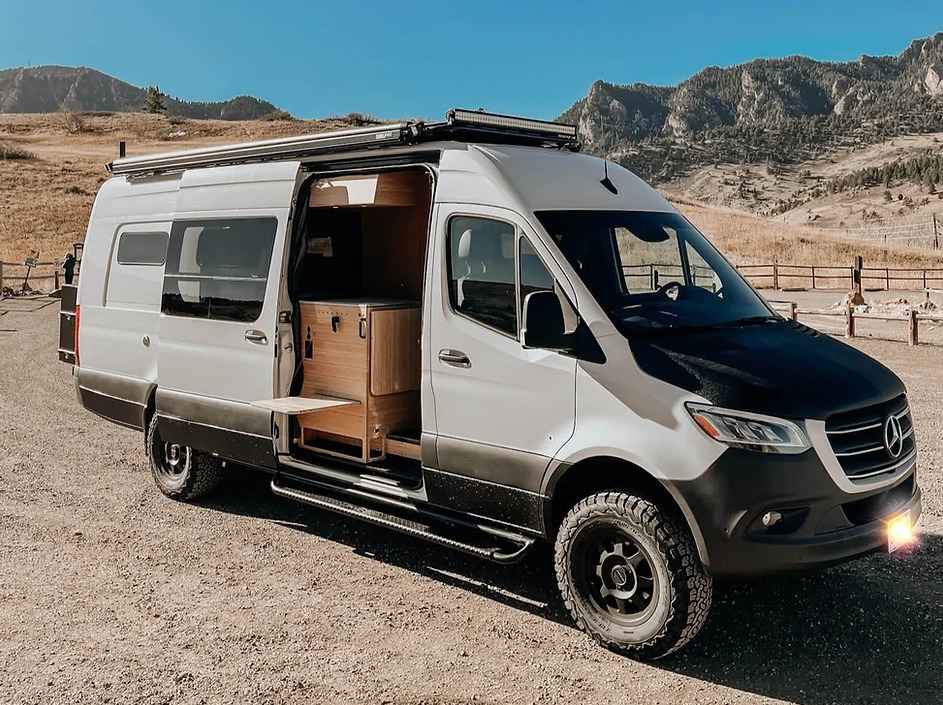 A view of a white and black boulder camper van with its door opened