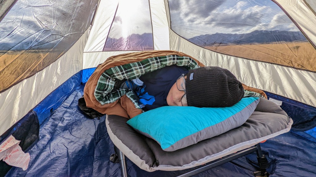 A view of a woman sleeping inside a tent resting on a pillow