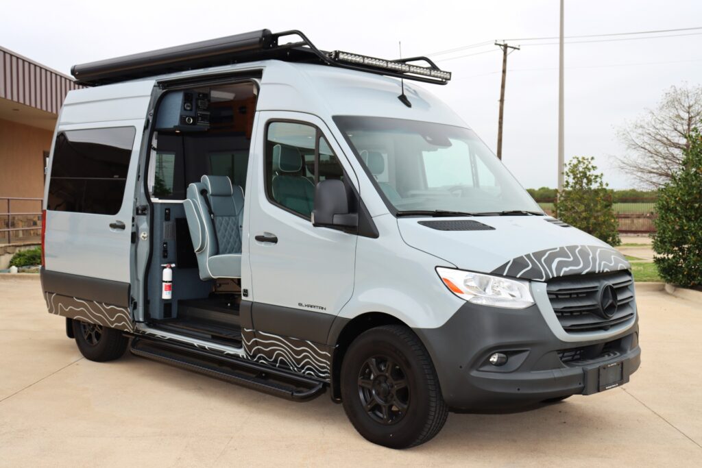 A view of grey and brown sprinter camper van with its door opened