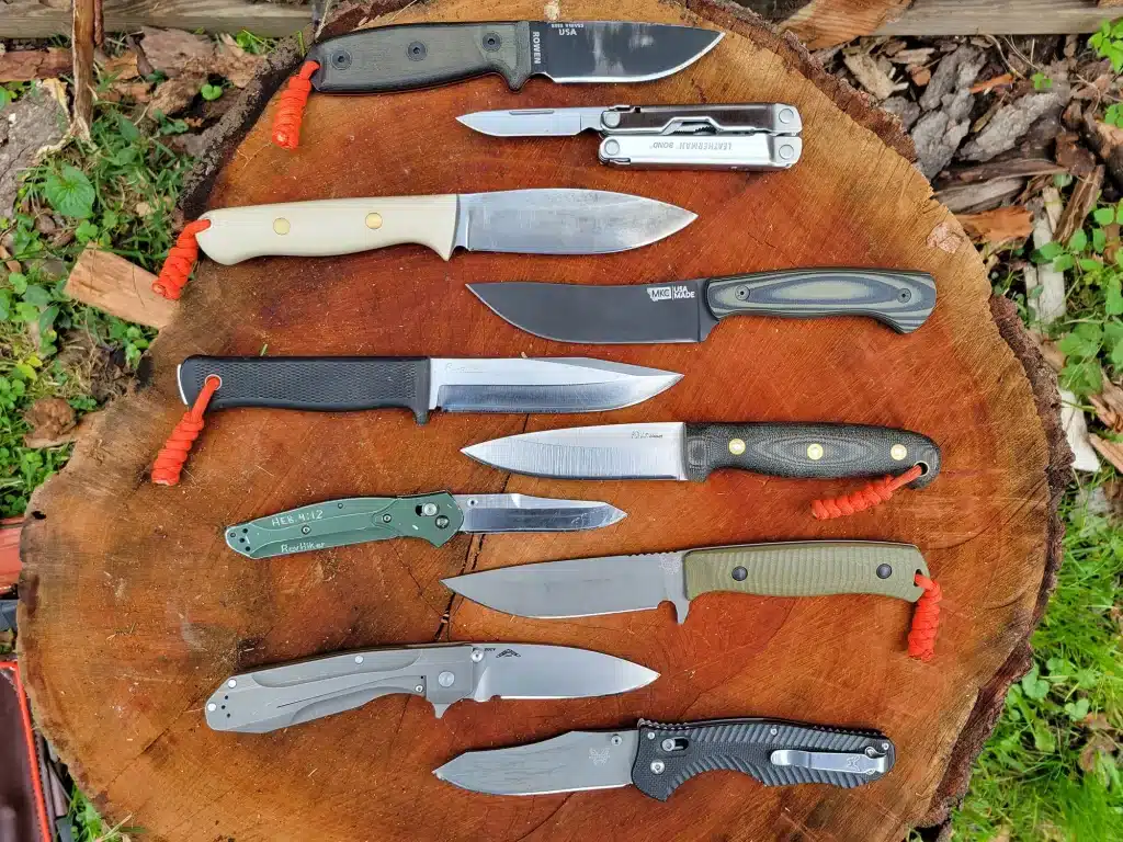 A view of multiple steel knives placed on a wooden log