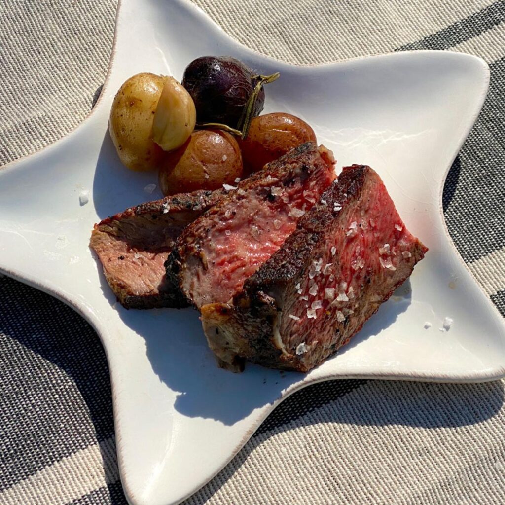 A view of steak and potatoes inside a white star shaped plate