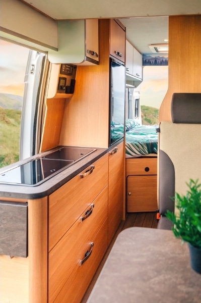 A view of the inside of a camper van with wooden drawers