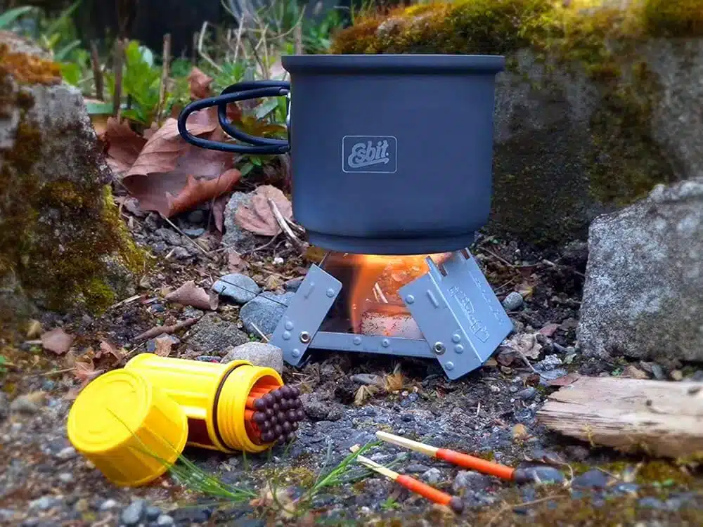 esbit stove on ground with fire lit