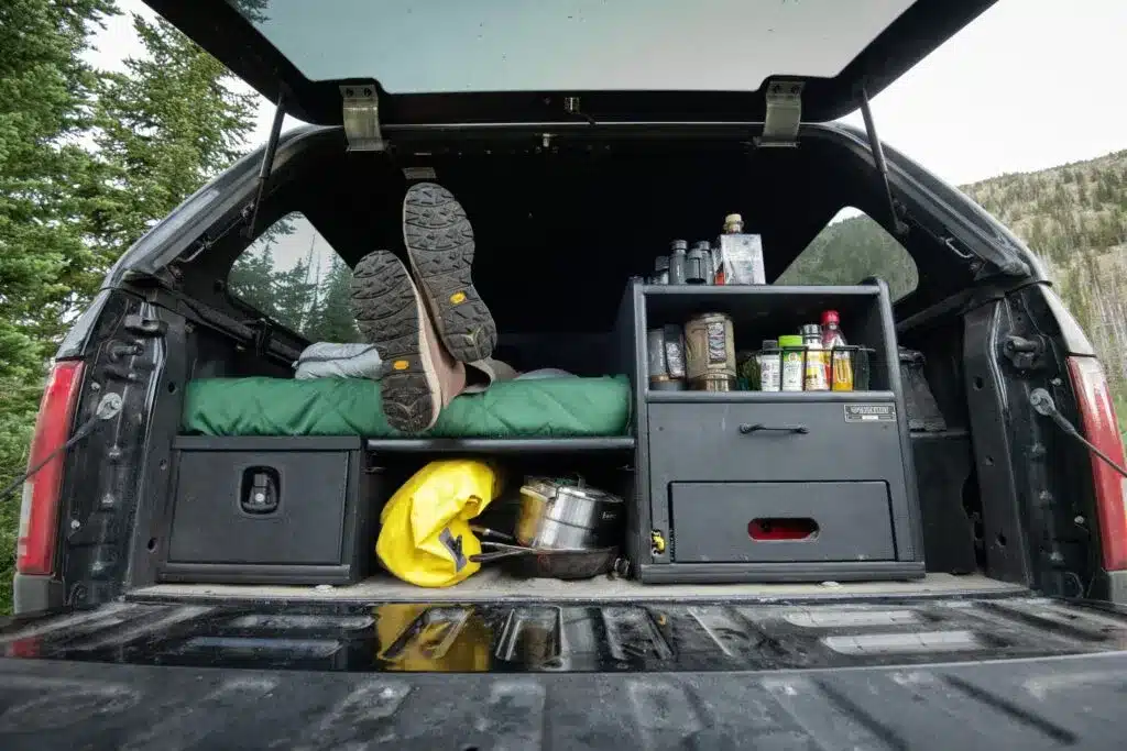 feet of a person in a truck bed items placed in storage drawers