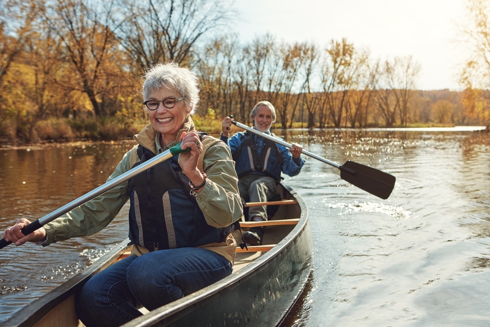 old couple happily kayaking 