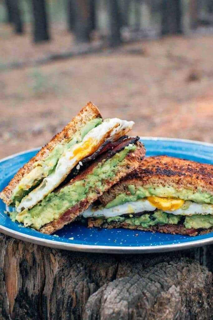 toasted avocado pieces in a blue plate placed on a wooden log