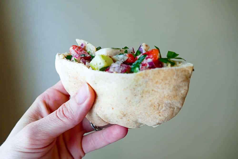 veggie pita and hummus in a hand