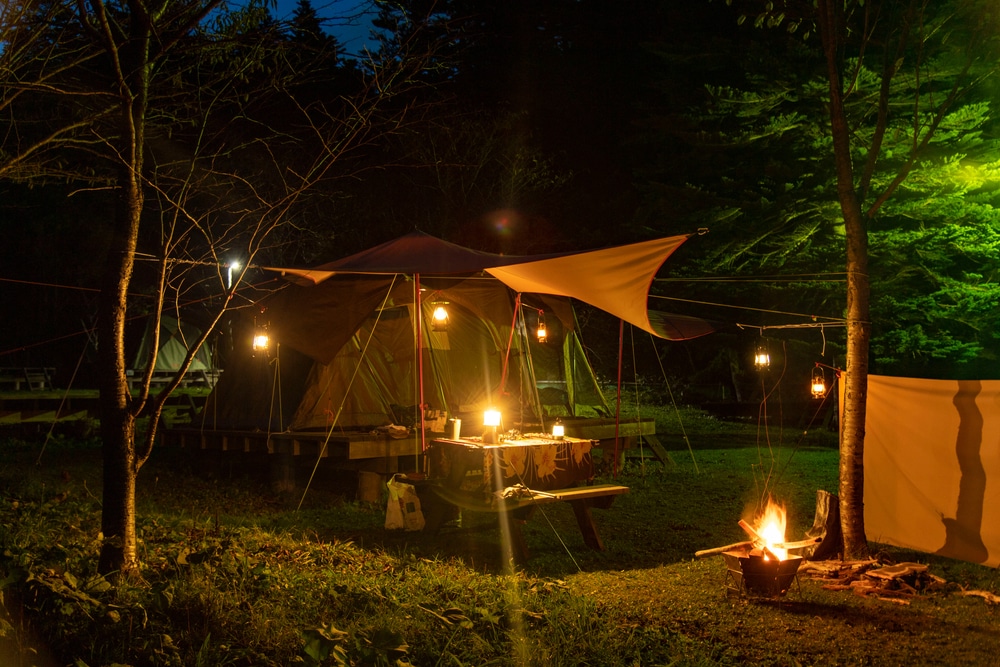 a sleeping tent in the outdoors with 7 lanterns