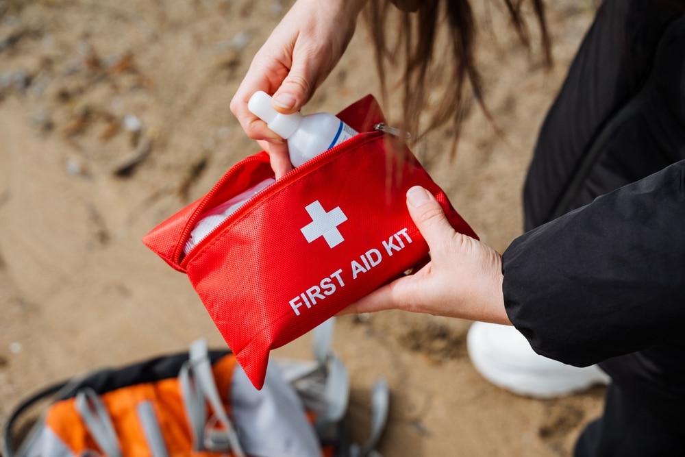 2 hands checking medicines in first aid pouch