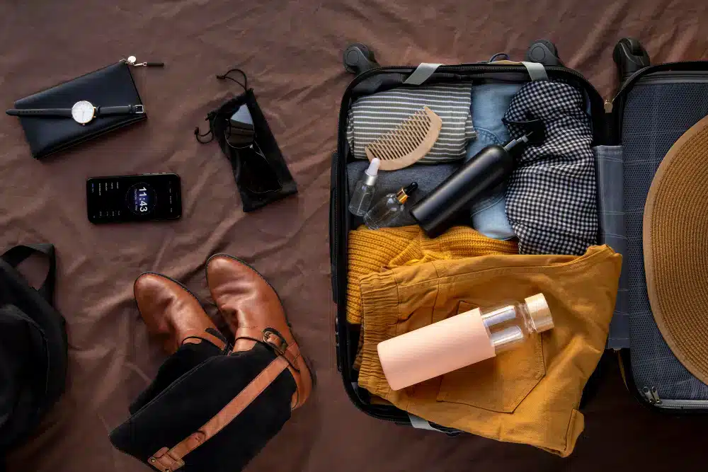 Travel suitcase and clothing items with a pair of boots