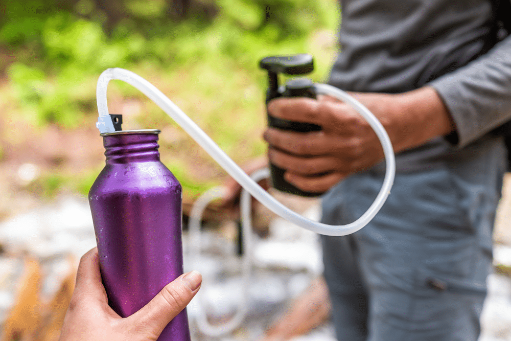 view of blurred hands one holding water bottle one holding filter